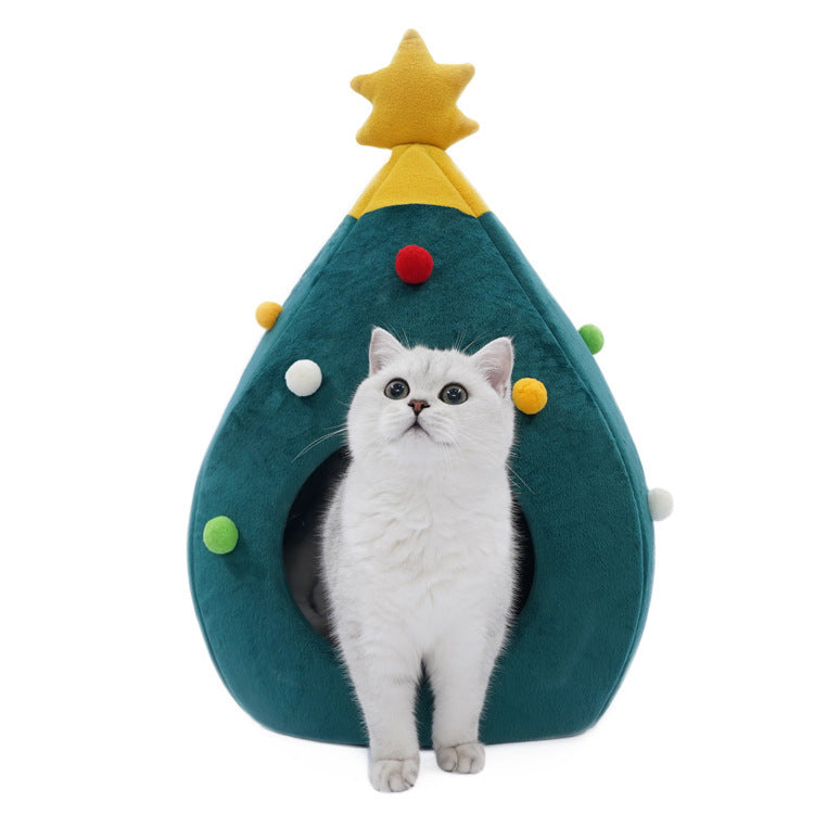 Cat sitting inside a green Christmas tree shaped cat bed