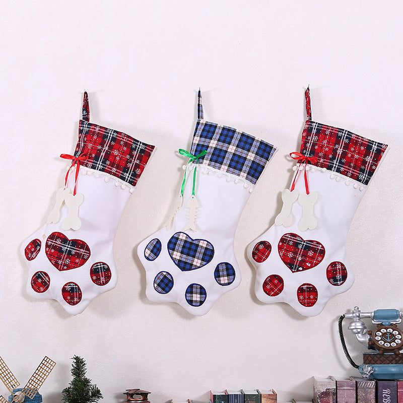 Paw-shaped Christmas stockings with tartan tops hanging on a mantelpiece