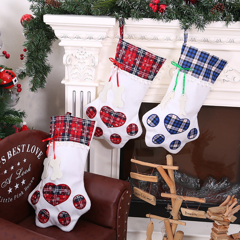 Paw-shaped Christmas stockings with tartan tops hanging on a mantelpiece