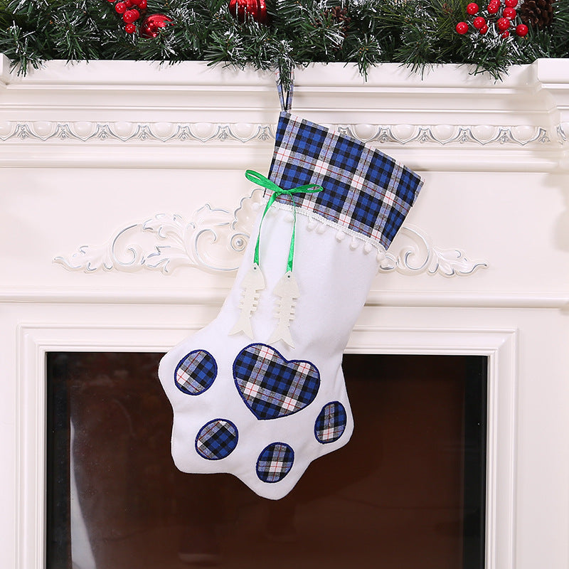 Paw-shaped Christmas stockings with tartan tops hanging on a mantelpiece