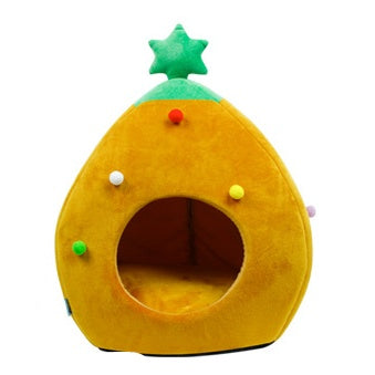 Cat sitting inside a green Christmas tree shaped cat bed