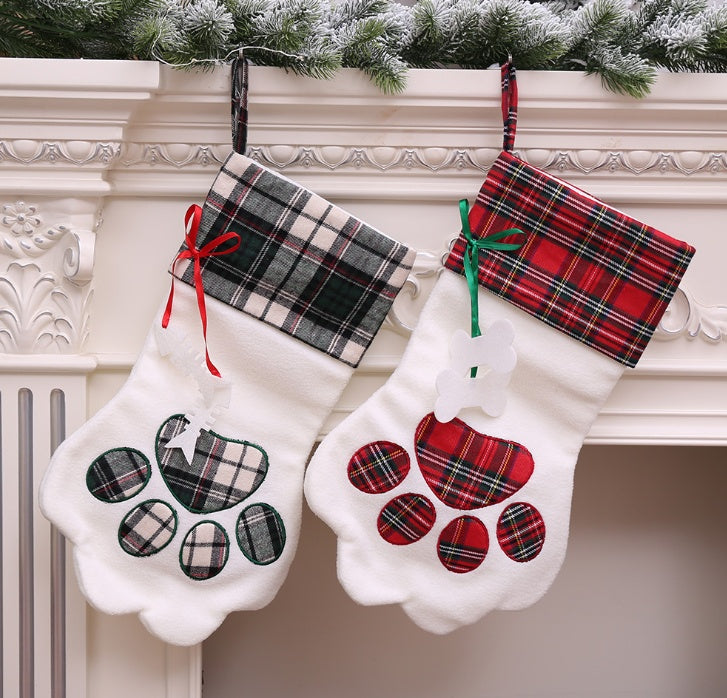 Paw-shaped Christmas stockings with tartan tops hanging on a mantelpiece