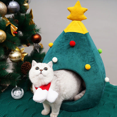 Cat sitting inside a green Christmas tree shaped cat bed