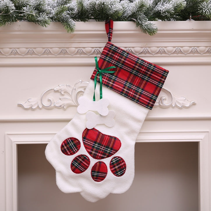 Paw-shaped Christmas stockings with tartan tops hanging on a mantelpiece
