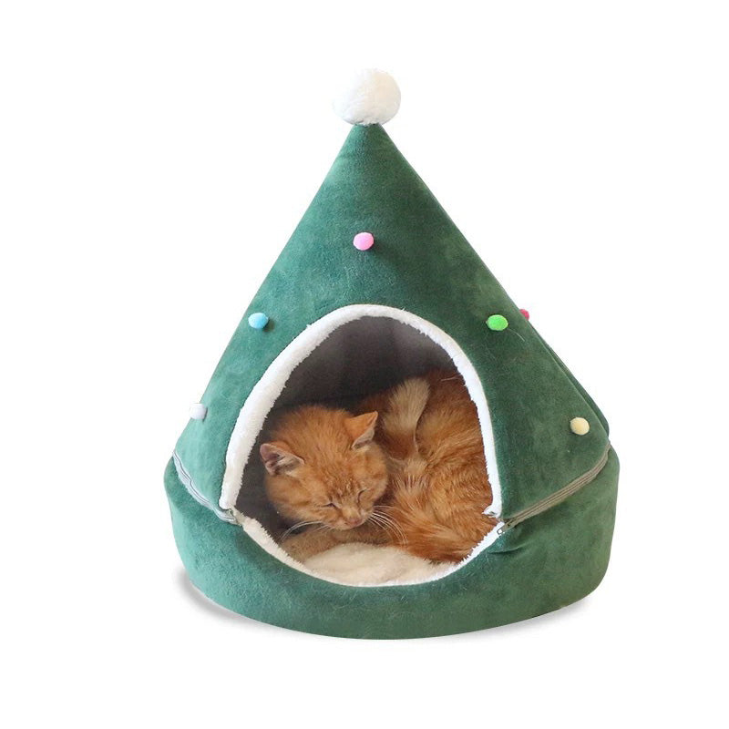 Cat sitting inside a green Christmas tree shaped cat bed