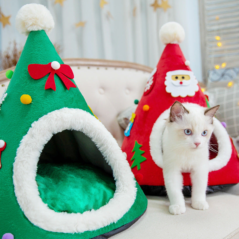 Cat in a red Santa hat shaped cat bed next to a green tree version